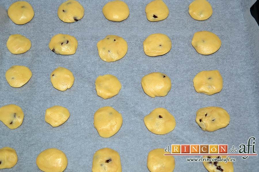 Galletas azucaradas con pepitas de chocolate, formar bolas con las manos y disponerlas en una bandeja de horno forrada