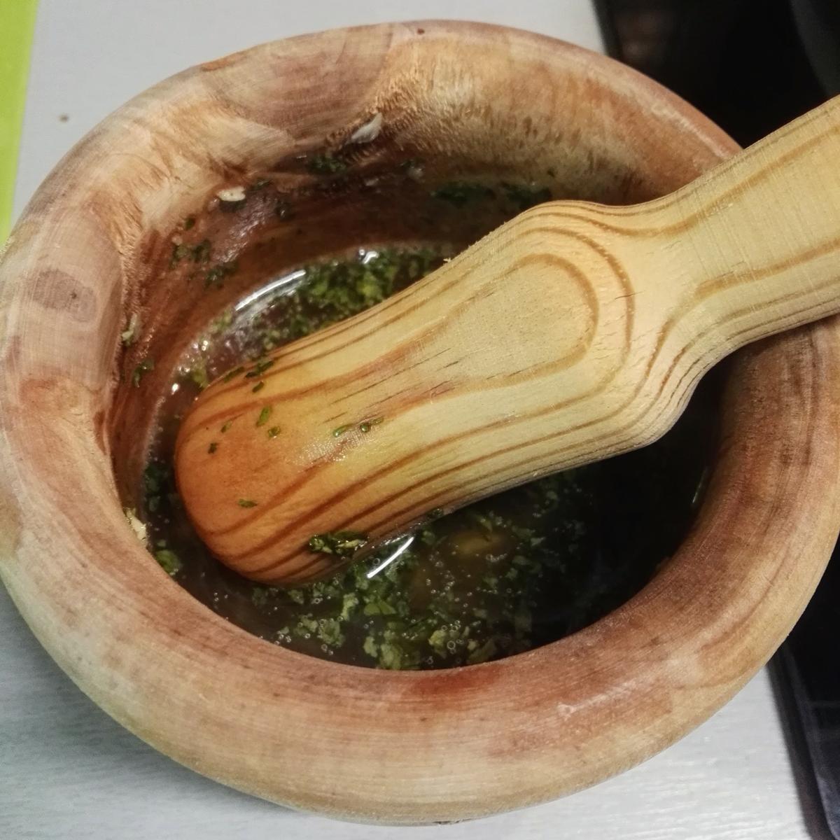 Usando el mortero para hacer un majao de brandy con perejil y ajo