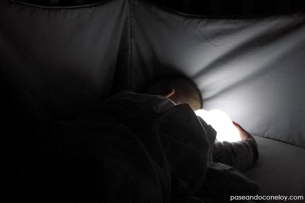 niño dormido en la cuna con una lámpara