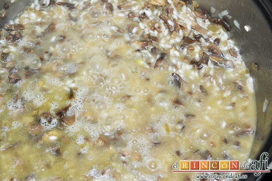 Risotto con champiñones, pera y nueces, añadir el caldo de verduras caliente cucharón a cucharón