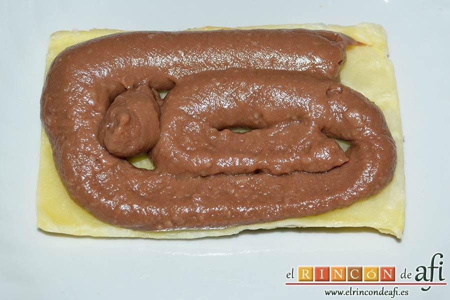 Milhojas de hojaldre con chocolate, poner una porción de crema sobre uno de los trozos de hojaldre