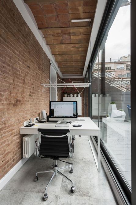 Despacho en porche patio Eixample con un gran ventanal. Techo con volta catalana.