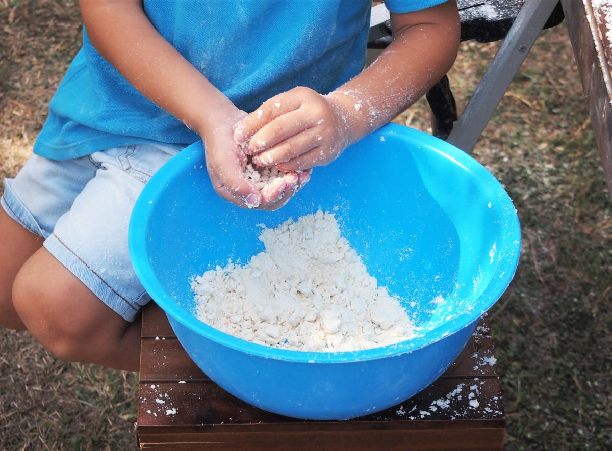 Niño haciendo arena mágica con sus manoscon sus manos