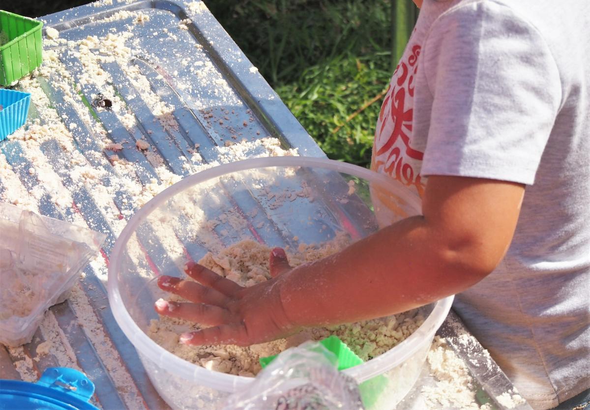 Niño haciendo arena mágica con sus manoscon sus manos