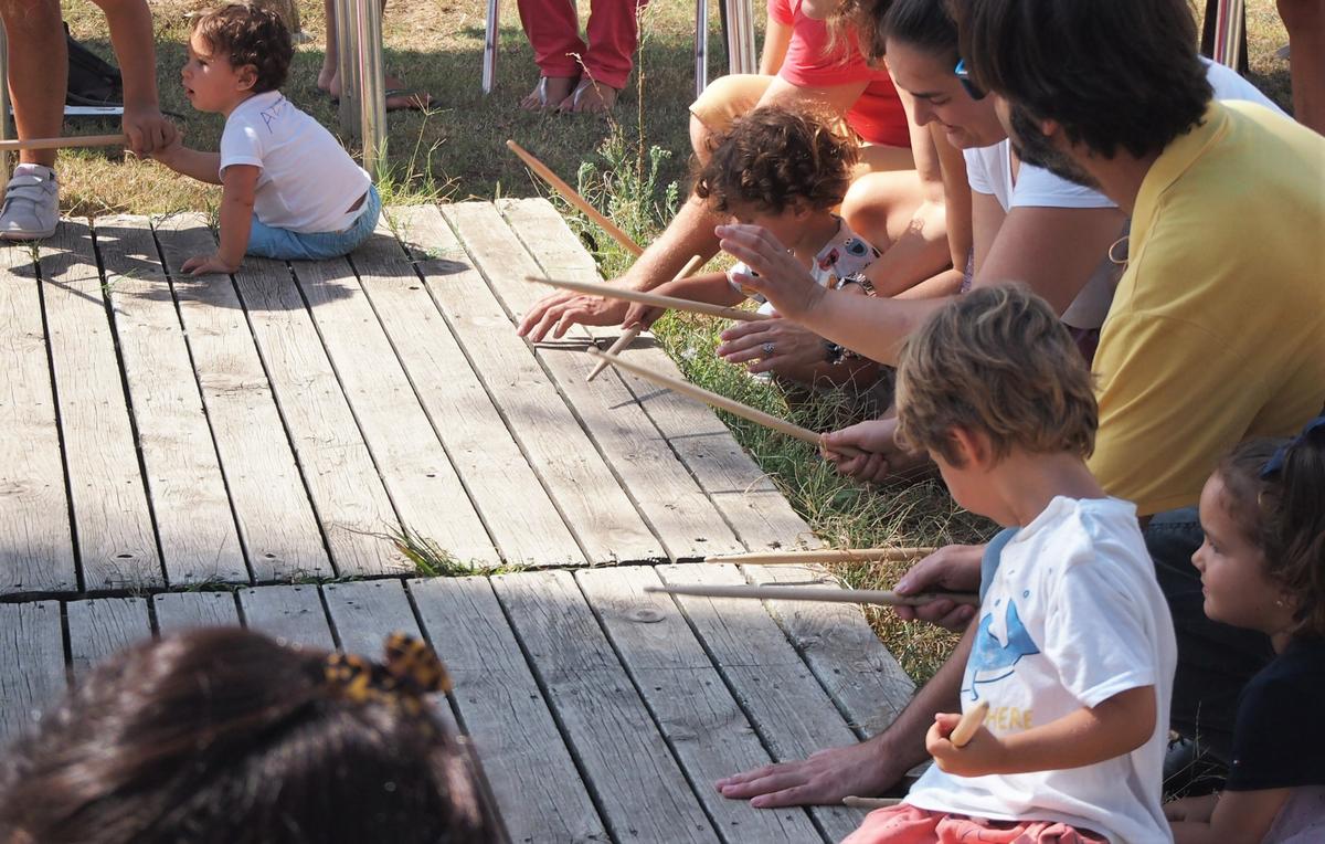 Niños tocando baquetas en la madera