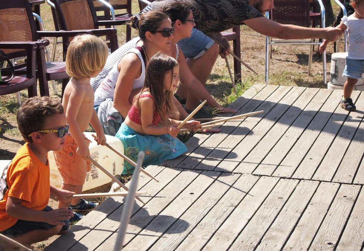 Niños tocando baquetas en la madera