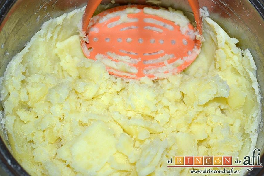 Brazo gitano de papa relleno de atún y pimiento, escurrir las papas y aplastarlas con un machacador