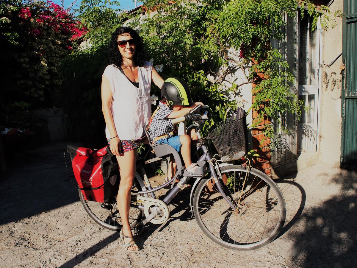 Mujer y niño en un bici. Rel niños esta sentado en una silla especial entre las piernas