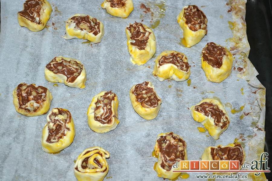Caracolas de Nutella y nueces, cortar en rodajas y colocarlas separadas sobre un papel de horno forrado con papel de horno