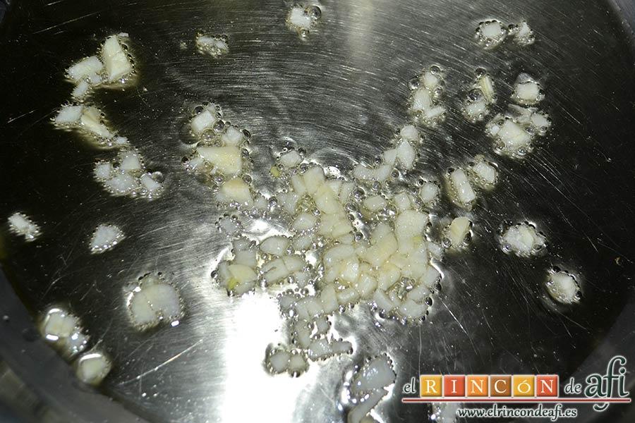 Merluza a la marinera, echar los ajos picaditos a un caldero con un fondo de aceite de oliva caliente