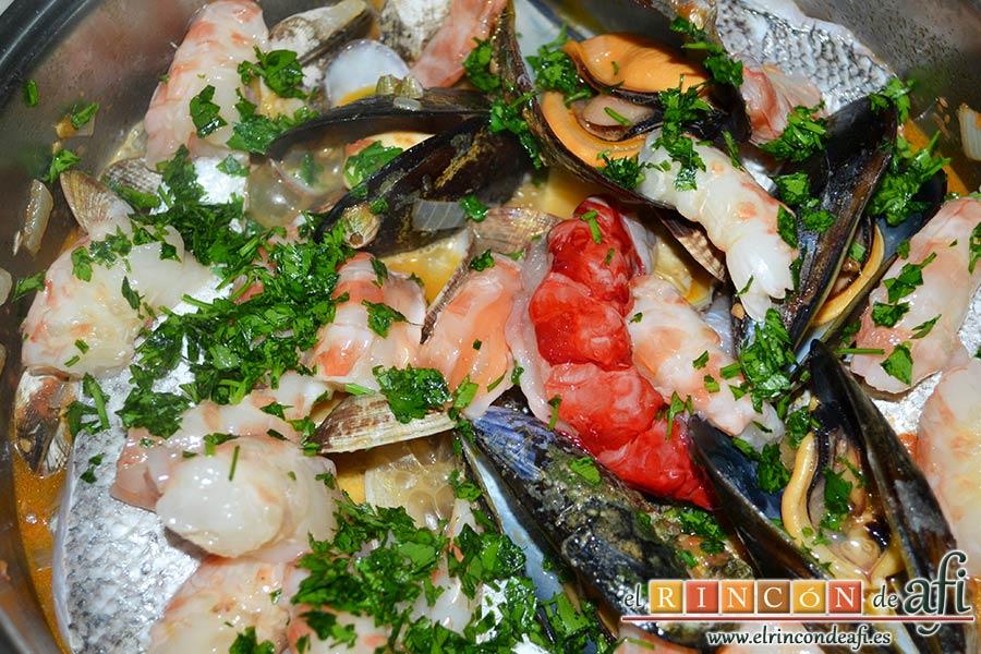 Merluza a la marinera, volver a tapar, mover y al destapar añadir el perejil fresco picadito