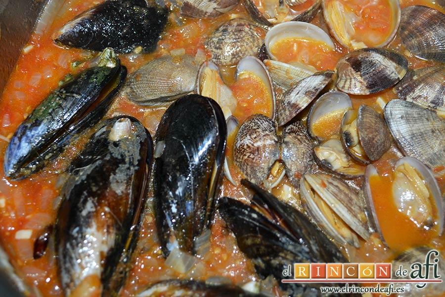 Merluza a la marinera, tapar unos minutos y comprobar que las conchas se han abierto