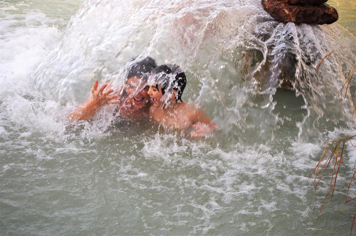 Mi hermana y mi sobrino debajo del chorro de agua caliente en las termas de Santa Fe, Granada