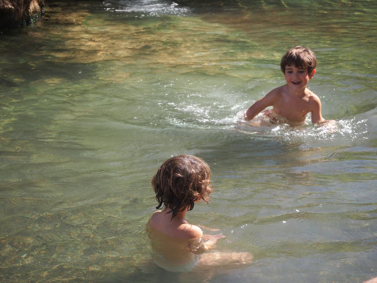 Los peques jugando en el agua en la poza de abajo, agua cristalina