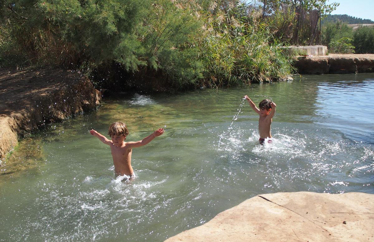 Los peques jugando en el agua en la poza de abajo