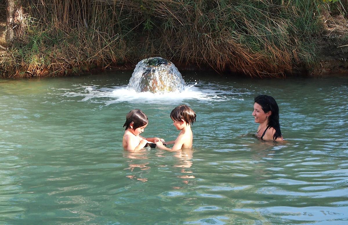 Nico y Eric jugando en el agua de la poza alta de las termas de Santa Fe, Granada