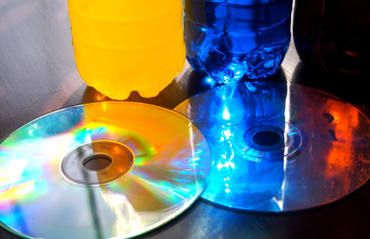 Juego de luz en la ventana. Las botellas con agua de colores dejando pasar la luz del color a los CDs