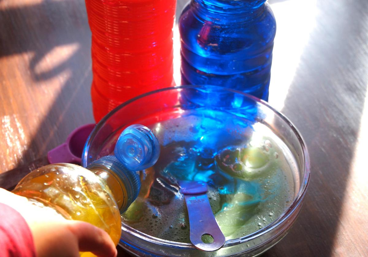 Juegos de transvases de liquido de colores con reflejos de la luz natural