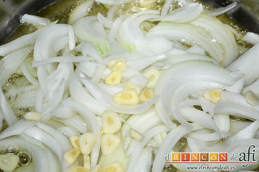 Bacalao en salsa de tomate y pimiento verde, poner a pochar en un caldero la cebolla troceada con los ajos laminados