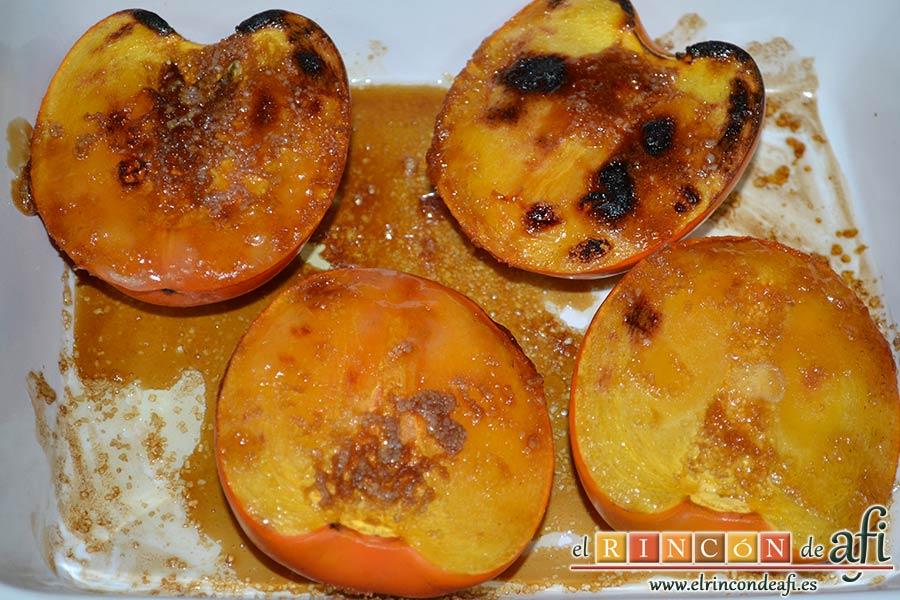 Kakis gratinados con crema de queso fresco, sacar los kakis del horno y prepararlos para la presentación poniendo por encima crema de queso