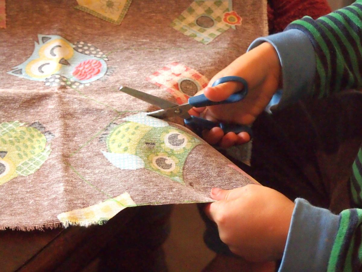 Manos de niños cortando tela para el calendario de adviento DIY