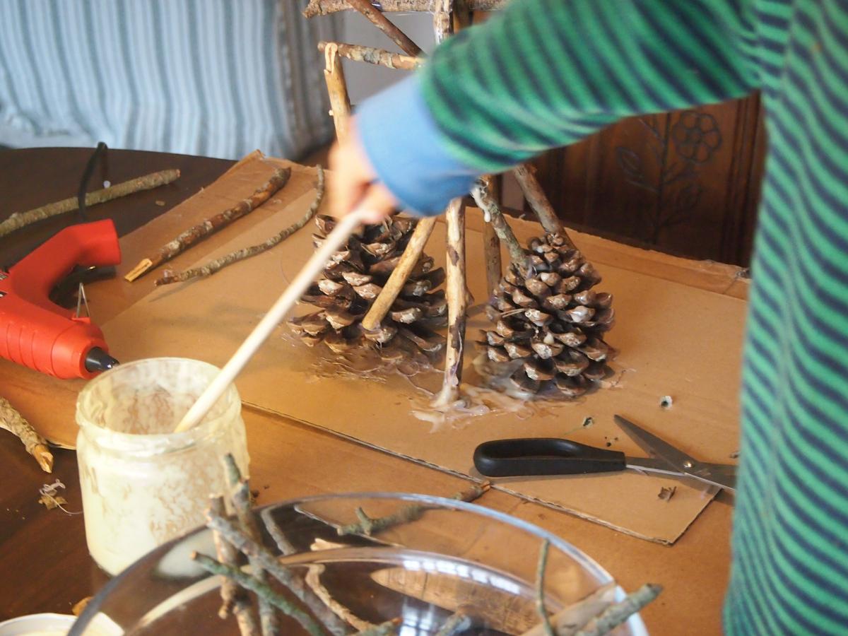 colocando y pegando los palos encima de las piñas 