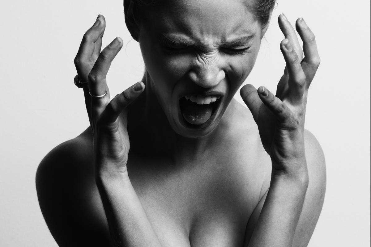 grayscale photography of woman opening her mouth while hanging her hands near her face