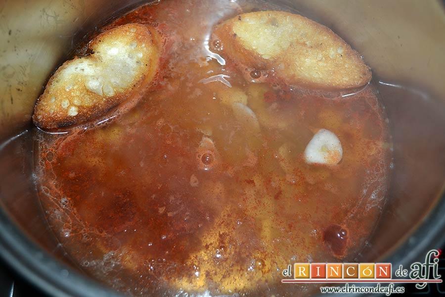 Sopa de ajo humilde, meter las rebanadas de pan frito en el caldero