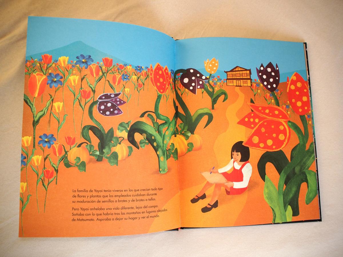 Una página del libro sobre Yayoi Kusama donde se le ve a ella pintando en el campo. Todo de colores vivos. 