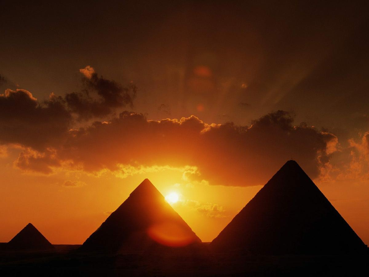 imágen de las pirámides durante el atardecer con el sol cayendo de fondo