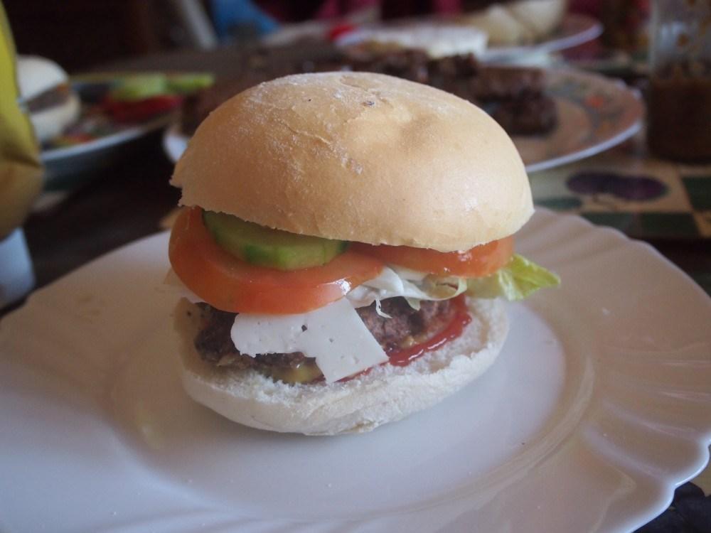 Hamburguesa veetariana de judias servida con pan y ensalada, queso y salsas