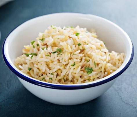 Rice pilaf with herbs in a white bowl