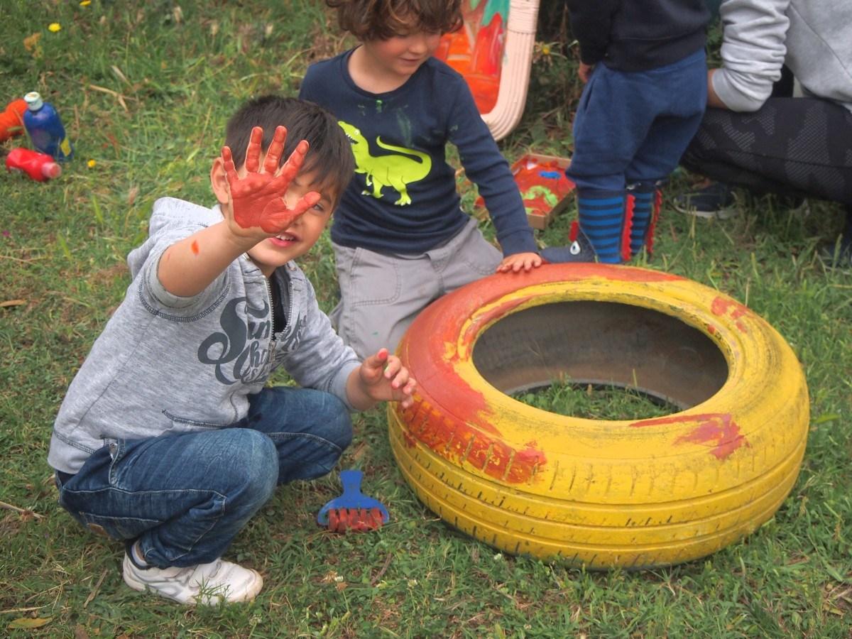 Pintando un neumatico viejo en el grupo de juego