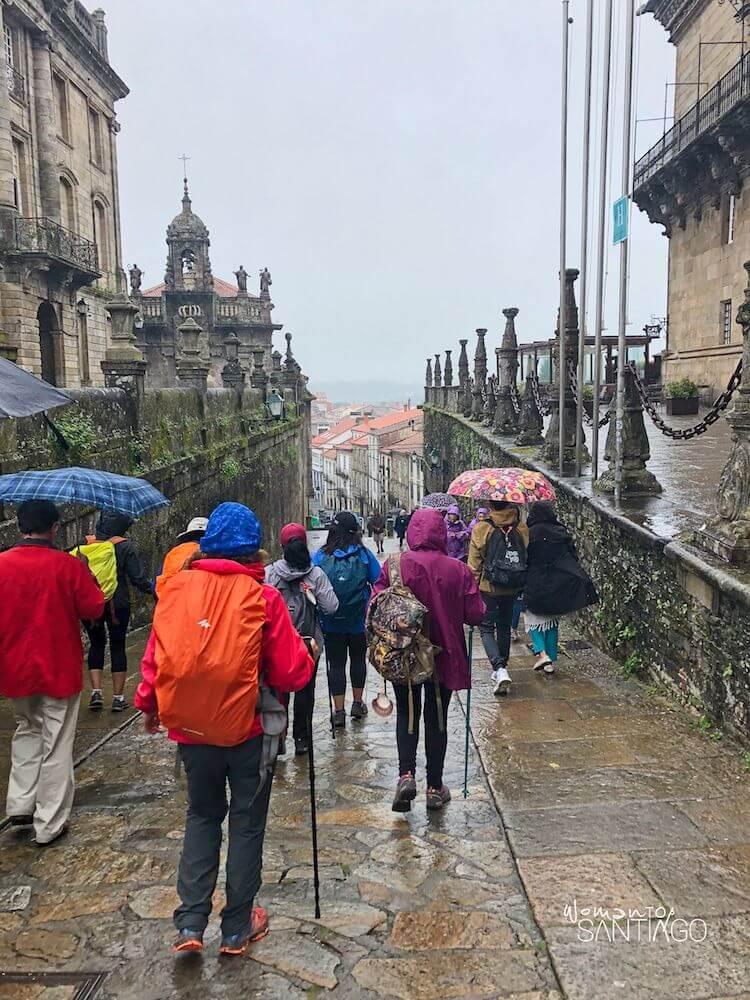 peregrinos con paraguas caminando