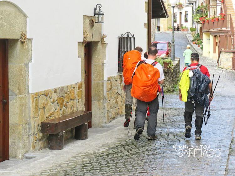 peregrinos con diferentes protecciones para la lluvia