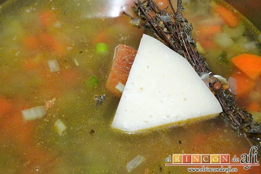 Pasta rota con lentejas, verter caldo hasta cubrir y el trozo de queso