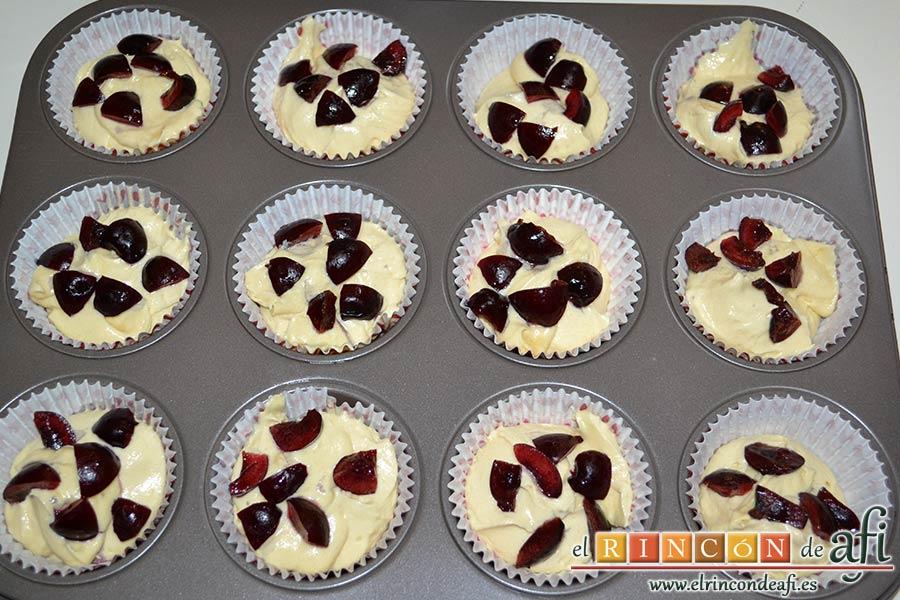 Cupcakes de cerezas al Kirsch, quitarles los rabitos y las pipas, trocearlas y ponerlas sobre la masa de las magdalenas