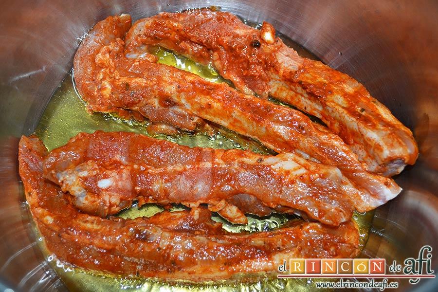 Guiso de costillas de cerdo adobadas con papas, poner a dorar las costillas de cerdo adobadas en una olla exprés con aceite de oliva