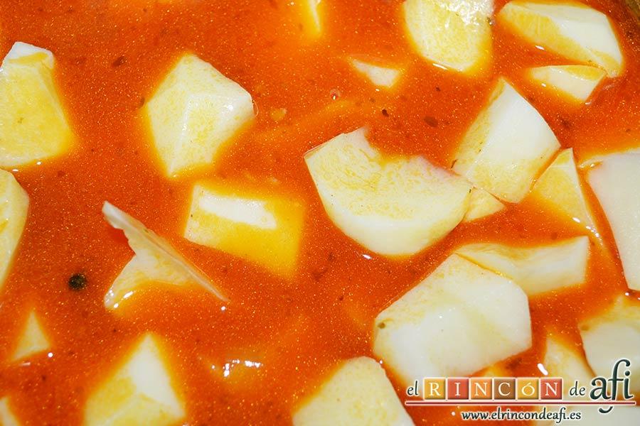 Guiso de costillas de cerdo adobadas con papas, añadir las papas a la olla