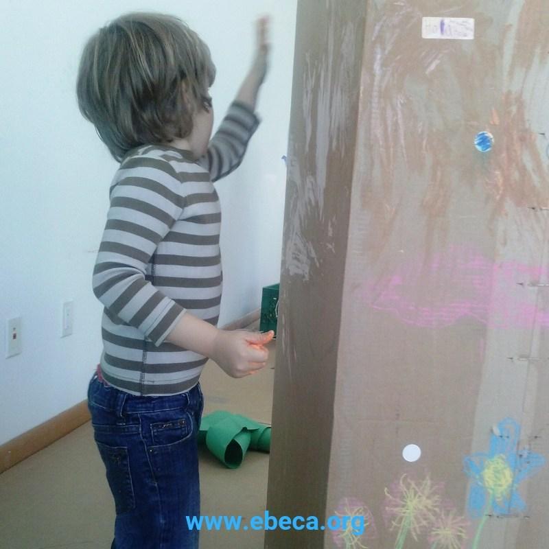 Un niño decorando una caja de cartón