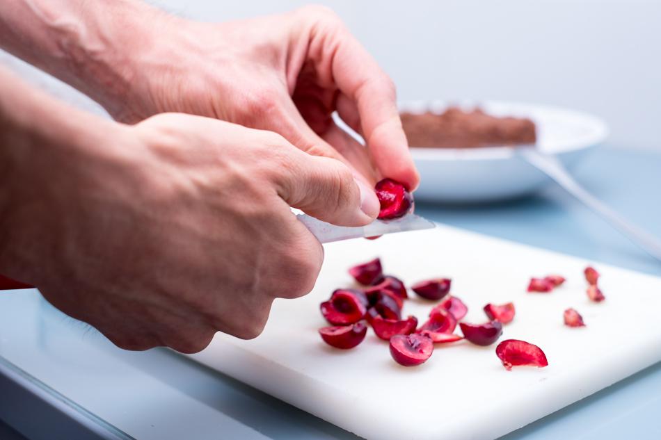 Sacando el hueso de las cerezas para hacer la mermelada cruda.
