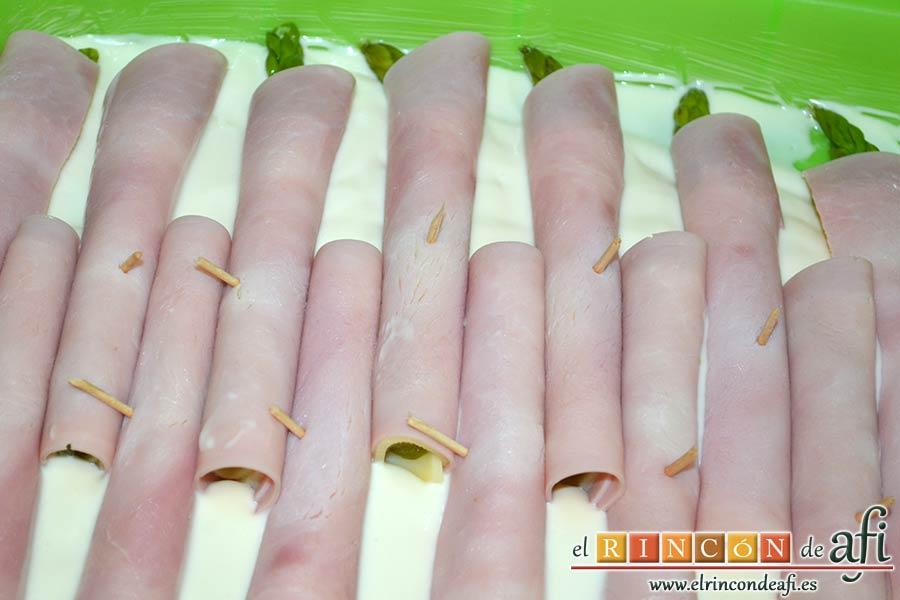 Rollitos de espárragos trigueros, ponerlos en la fuente de horno sobre la bechamel alternando la posición, a derecha e izquierda