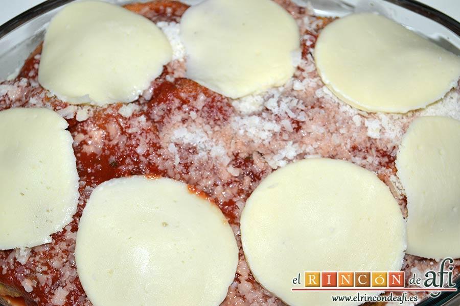 Berenjenas a la parmesana, espolvorear con queso parmesano y lonchas de mozzarella