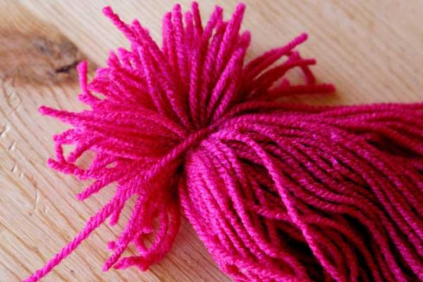 unir lana rosa para hacer un pulpo de lana