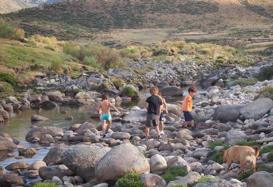 Niños caminando por las tocas del lecho de un rio