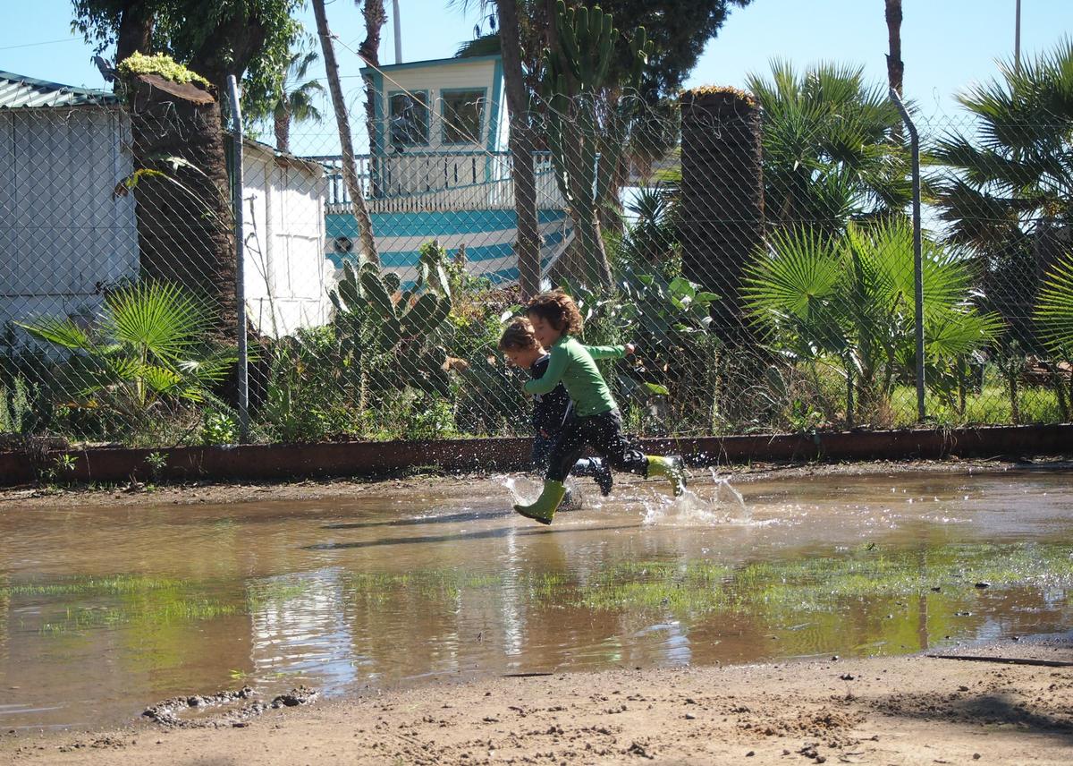 Niños chapoteando en los charcos despues de las lluvias