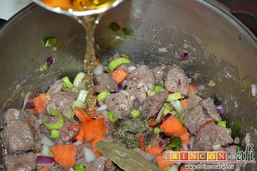 Estofado de ternera otoñal, añadir el vino blanco, el tomillo y la hoja de laurel