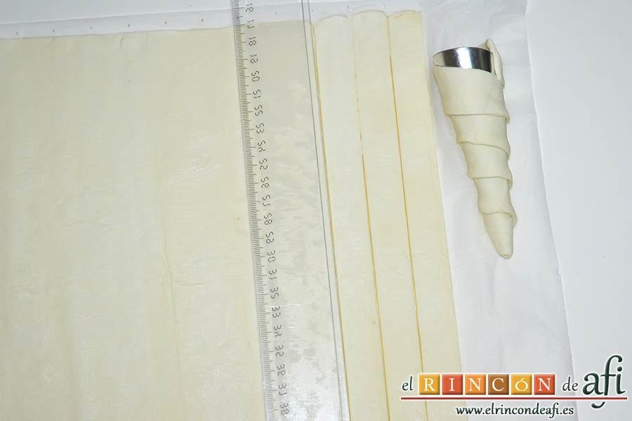 Conos de hojaldre rellenos con crema pastelera, estirar la lámina de hojaldre y cortarla en tiras