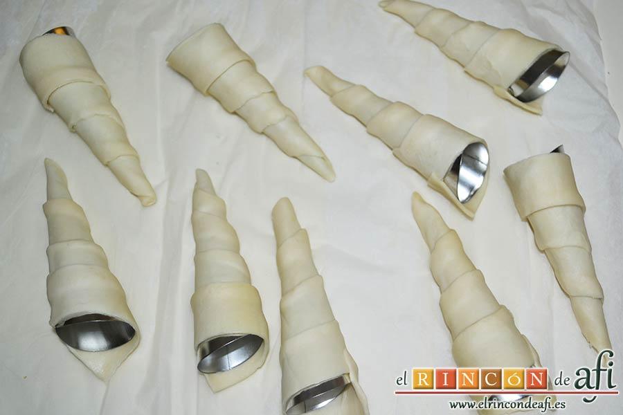 Conos de hojaldre rellenos con crema pastelera, envolver los conos con las tiras