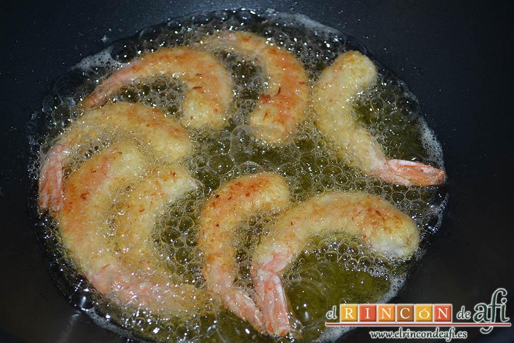 Langostinos rebozados con coco, darles la vuelta para que se doren por ambas caras